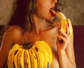 Une femme mange sensuellement une banane